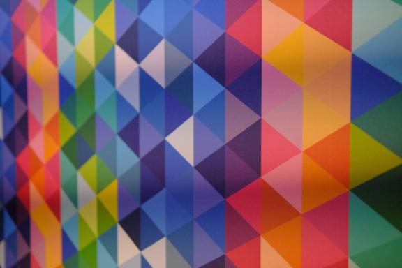 A wall tiled with bright geometric triangles in many colours.