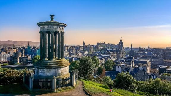 The Edinburgh skyline from Calton Hill, with the Dugald Stewart Monument in the foreground and the castle in the distance.