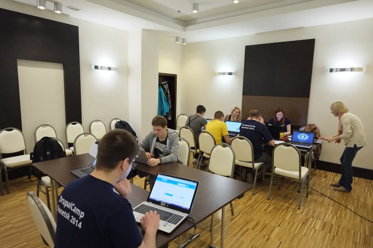 A small group working on laptops around tables at DrupalCamp Donetsk