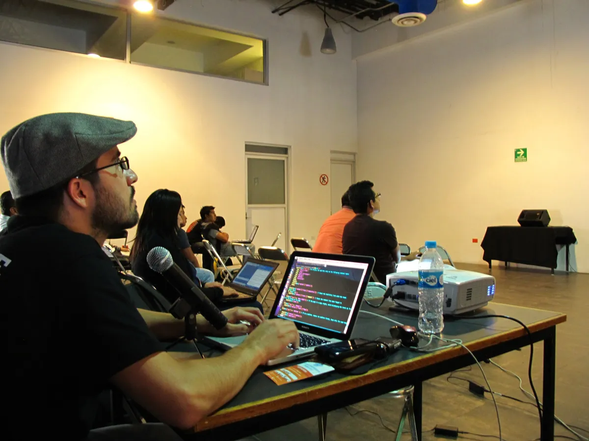 A developer with code on his laptop screen during a workshop at DrupalCamp Puebla