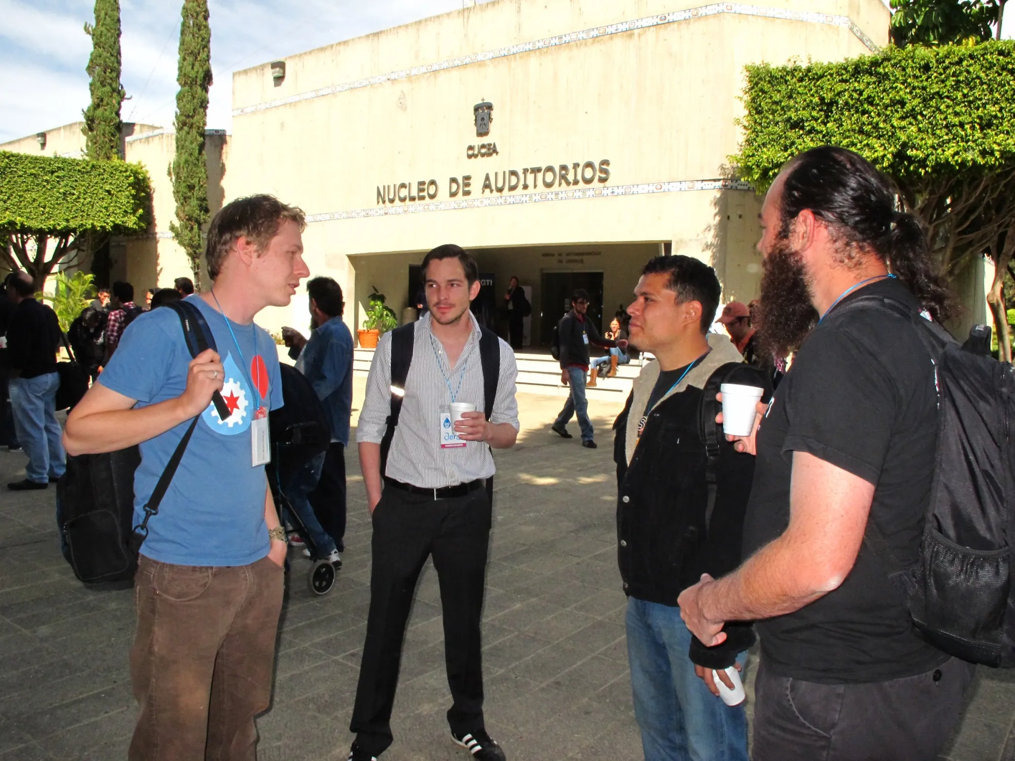 Four Drupal developers talking outside a conference venue in Guadalajara