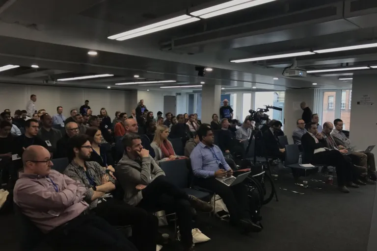 An audience listening to a talk in a seminar room at DrupalCamp London 2017.