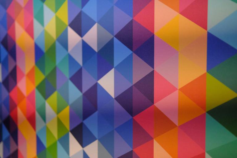 A wall tiled with bright geometric triangles in many colours.